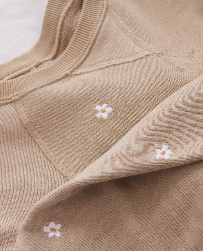 The Slouch Sweatshirt by THE GREAT. PF25 EMB KNITS in khaki features white daisy embroidery scattered across the fabric.