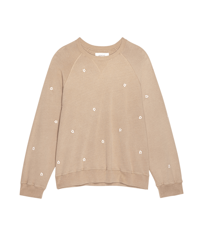 The Slouch Sweatshirt by THE GREAT. SP25 D2, in khaki with delicate white daisy embroidery, raglan sleeves, and ribbed cuffs and hem, is displayed on a white background.