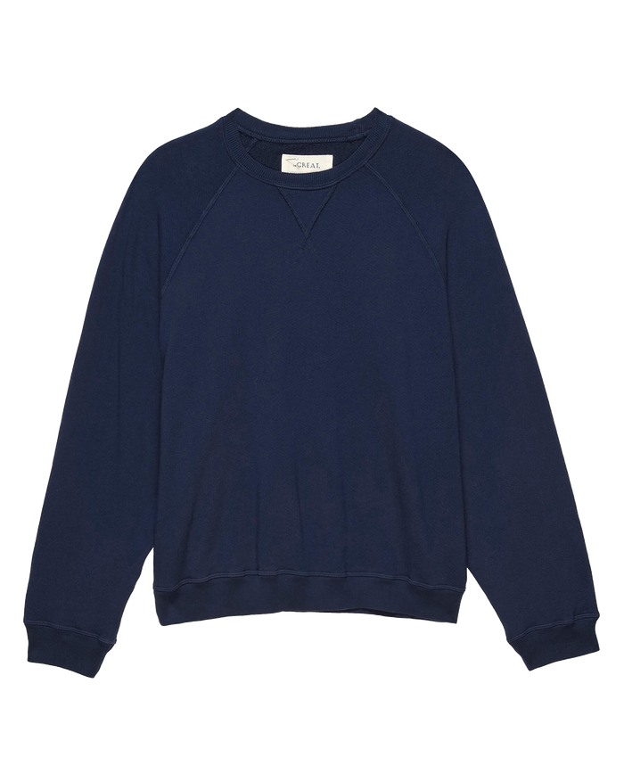 The Slouch Sweatshirt in Solid True Navy by THE GREAT., from their FALL 23 KNITS collection, offers a vintage-inspired look with its long sleeves and round neckline, ideal for achieving a relaxed yet stylish appearance.