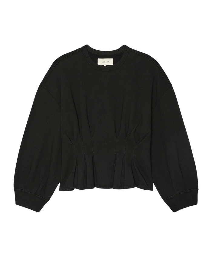 The Slouchy Corset Sweatshirt by THE GREAT. in True Black features long sleeves, a crewneck, gathered pleats at the waist, and a slightly cropped hem. This vintage-inspired French terry top is handcrafted in Los Angeles.