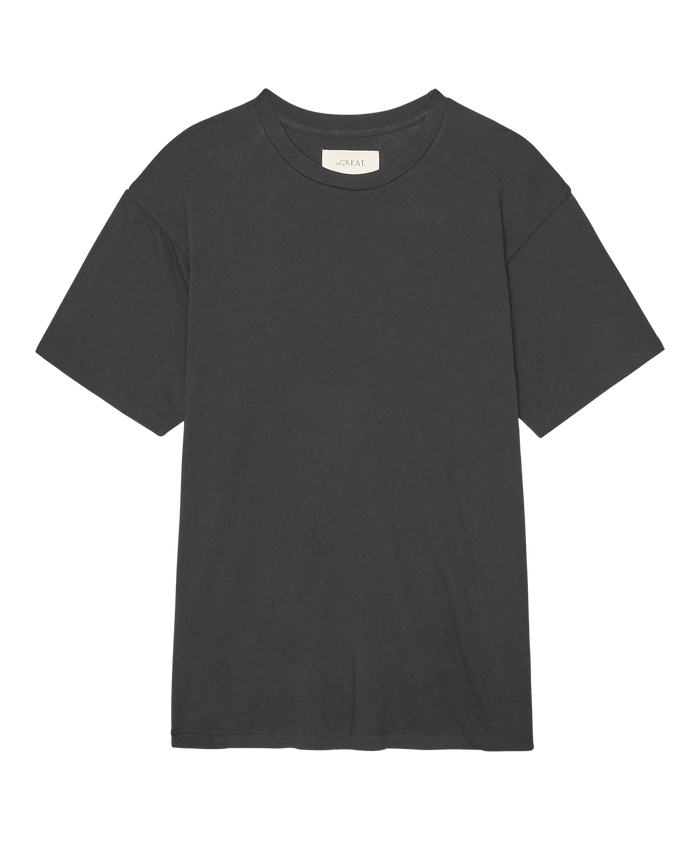 The Slouchy Crew Tee in Almost Black by THE GREAT. SP26 SEASONAL CORE, a relaxed short-sleeve crew neck in soft jersey fabric, is laid flat on a white background.