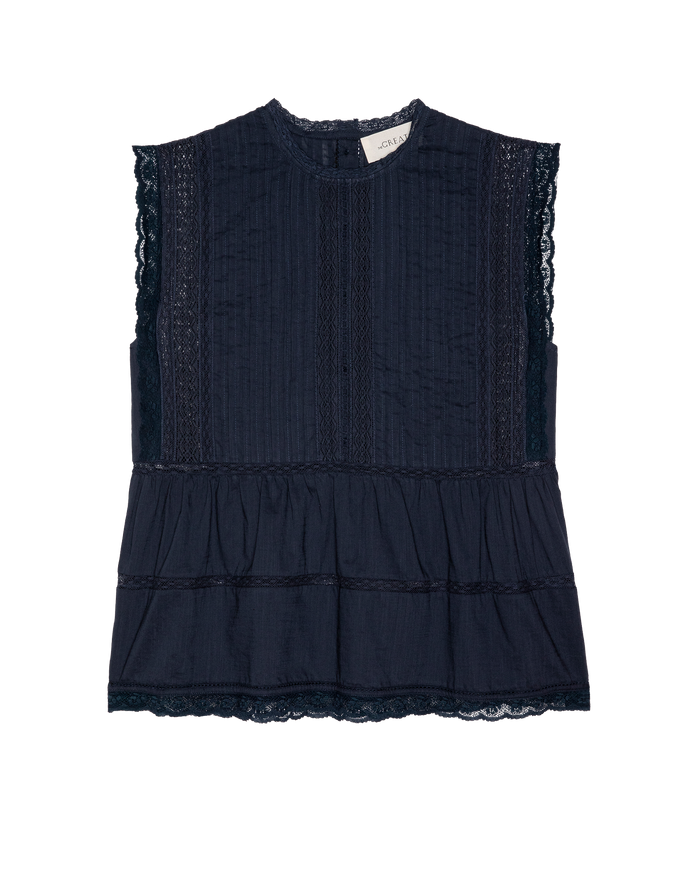 The Sonnet Top in navy by THE GREAT. SP26 D1 is a sleeveless blouse with lace details, pintuck panels, and a ruffled lower section, shown on a white background.