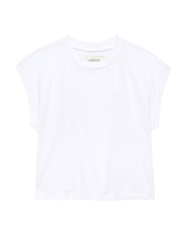 The Square Tee in True White from THE GREAT. SU23 CORE KNITS is a plain white, short-sleeved T-shirt featuring slightly rolled sleeves and a classic crew neckline, making it the perfect match for high-waisted denim, showcased against a pristine white backdrop.