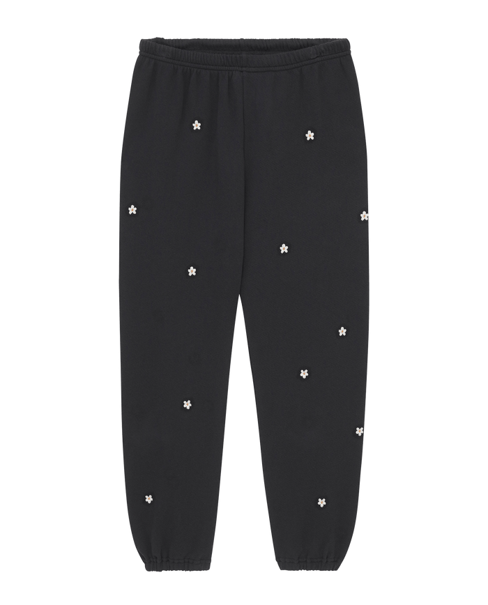 The Stadium Sweatpant by THE GREAT. PF25 EMB KNITS features an elastic waistband and cuffs, in almost black with scattered daisy embroidery for a charming touch.