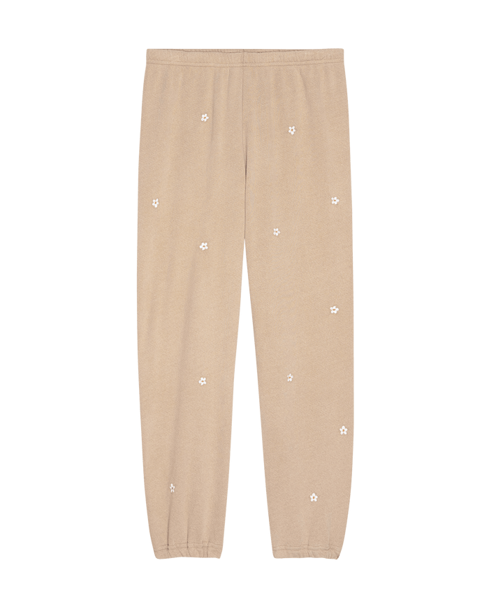Khaki Stadium Sweatpant with daisy embroidery from THE GREAT. SP25 D2, features an elastic waistband and cuffed ankles, displayed on a plain black background.