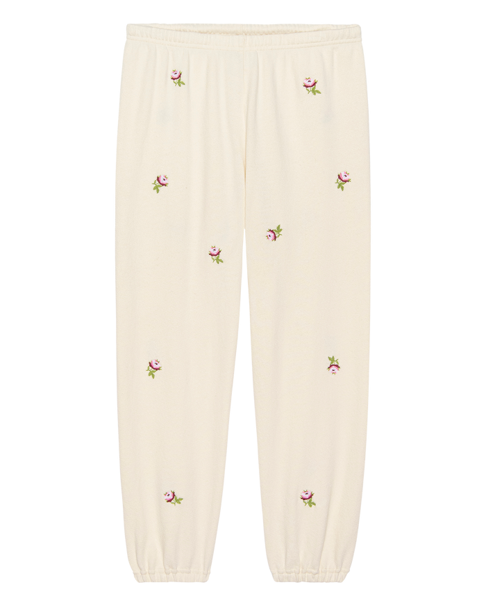 THE GREAT. H25 ROSEBUD's The Stadium Sweatpant in washed white features an elastic waistband, cuffs, and embroidered rose details for a vintage-inspired look.