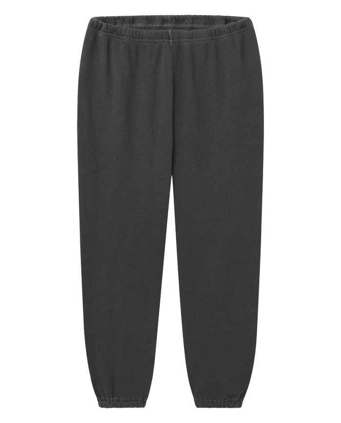 The Stadium Sweatpant in Washed Black by THE GREAT. CORE KNITS is a pair of vintage athletic sweatpants made from 100% cotton, featuring an elastic waistband and elastic cuffs at the ankles.