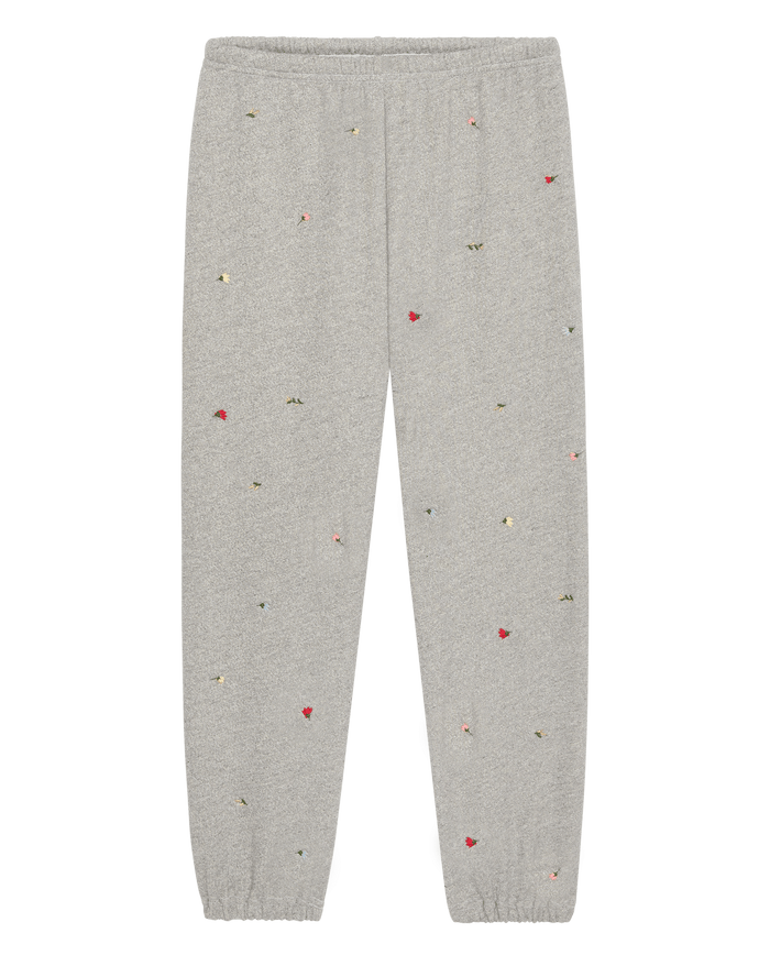 The Stadium Sweatpant W/ Tossed Floral Emb. by THE GREAT. SU26 in Varsity Grey features an elastic waistband and cuffs, plus scattered colorful floral embroidery for a playful twist on vintage athletic style.