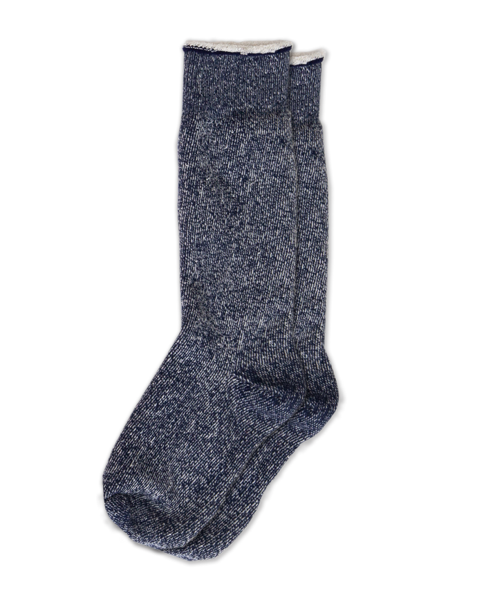 The Sweatshirt Sock by THE GREAT. SP25, in navy blue, exemplifies cozy fashion with its blue and gray marled wool against a black backdrop.