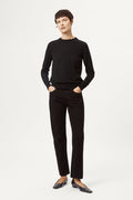 Person wearing a black sweater and black pants on a white background