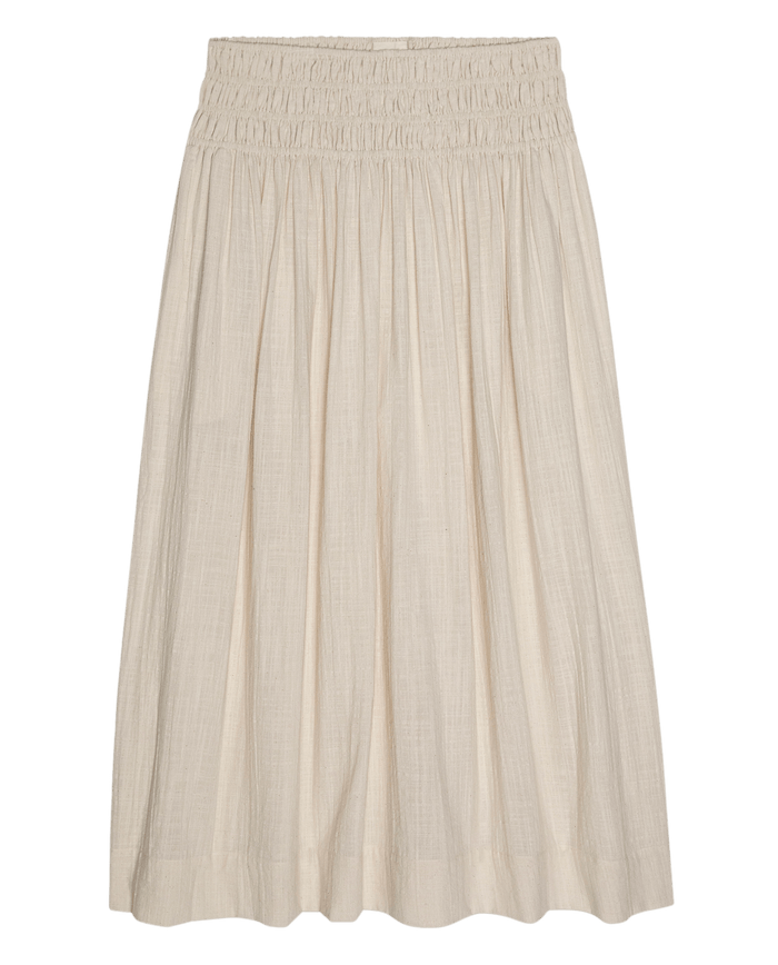 The Viola Skirt in Natural by THE GREAT. SU26 features a knee-length cut, elastic smocked waistband, and loose pleats for effortless style.