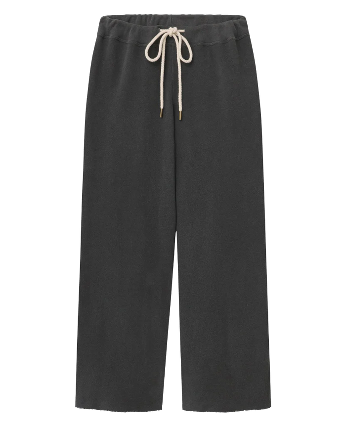 The Wide Leg Cropped Sweatpant in washed black by THE GREAT. CORE KNITS features a white drawstring waist and wide cropped legs, displayed against a white background.