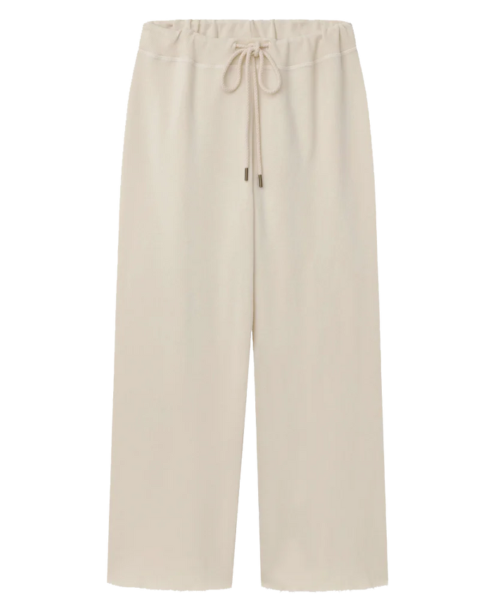 Laid flat against a white background, The Wide Leg Cropped Sweatpant in Washed White from THE GREAT. CORE KNITS features a beige drawstring waist and is made of 100% cotton.