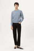 Woman wearing a wool light blue sweater on a white background