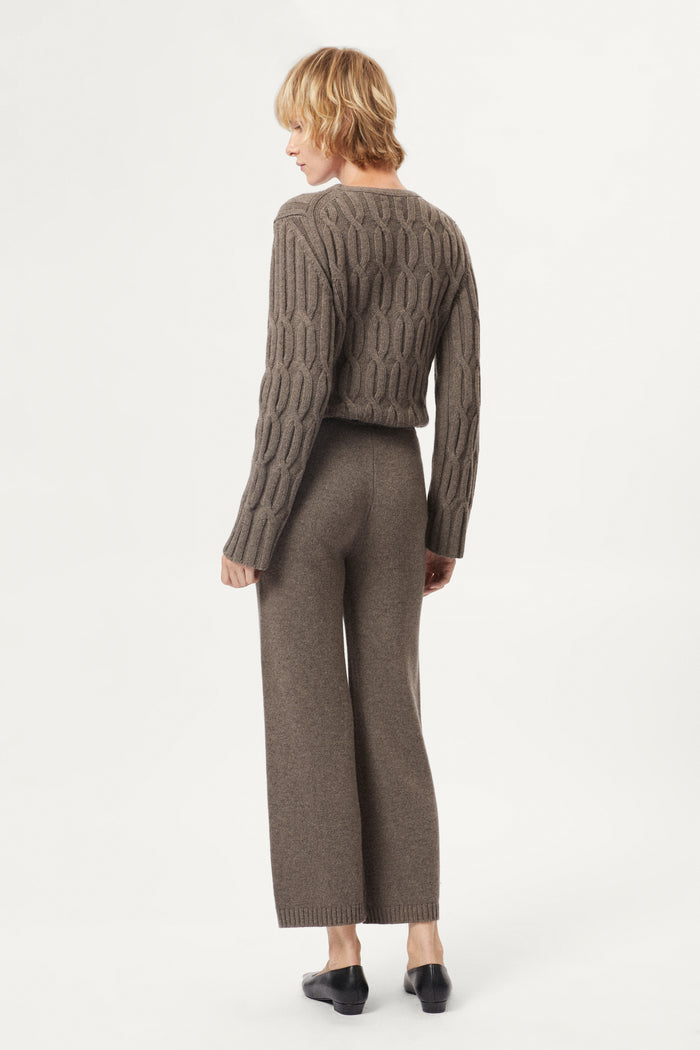 Woman wearing a brown cable knit sweater and matching taupe woolen knitted pants