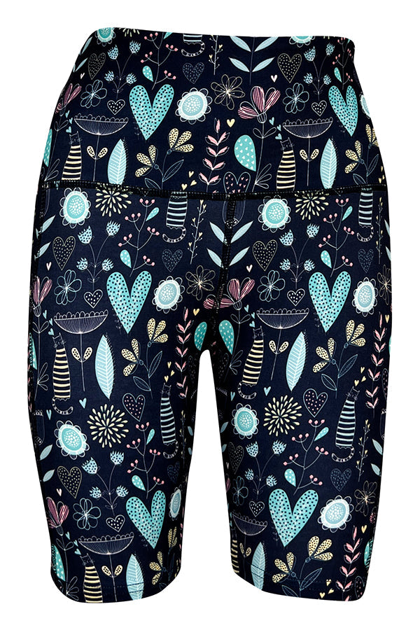 Wildflower Whiskers Shorts with floral, heart, and striped kitty designs on blue background, featuring deep side pockets and extra stitching for structure