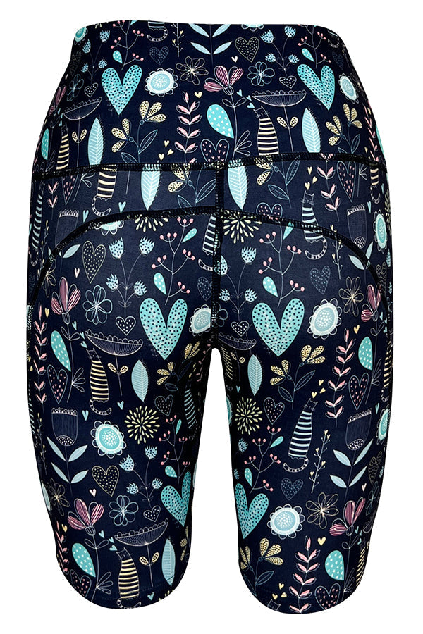 Dark blue Wildflower Whiskers Shorts with floral, heart, and striped kitty designs, featuring deep side pockets and structured stitching.